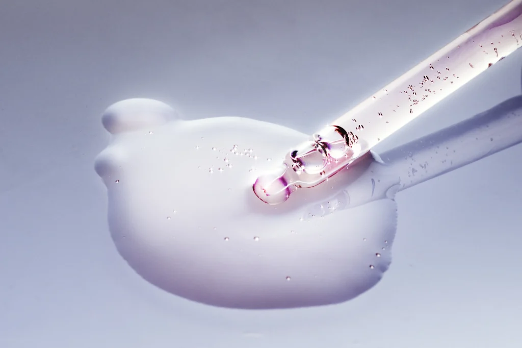 Oil dropper background pink dripping cosmetic product