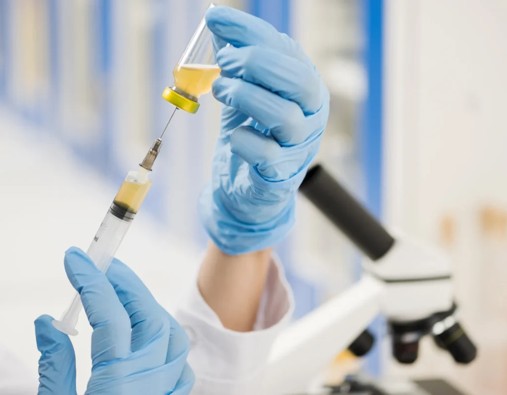 Scientist with surgical gloves filling up syringe